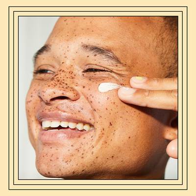 person applying moisturizer to cheekbone